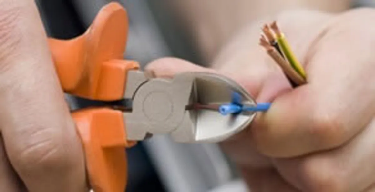 licensed electrician performing precise wire cutting and preparation during electrical service in Cherry Hill, NJ